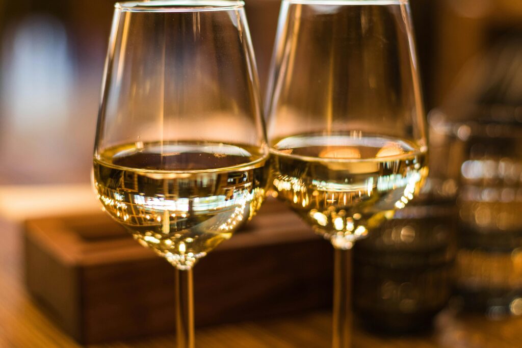 pexels-photo-1123260-1123260 Two elegant wine glasses filled with white wine, captured with a beautiful bokeh effect.