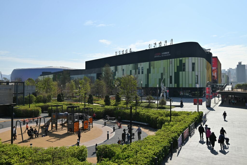 pexels-photo-31555578-31555578 Busy outdoor shopping mall with a lively playground and lush greenery in daylight.